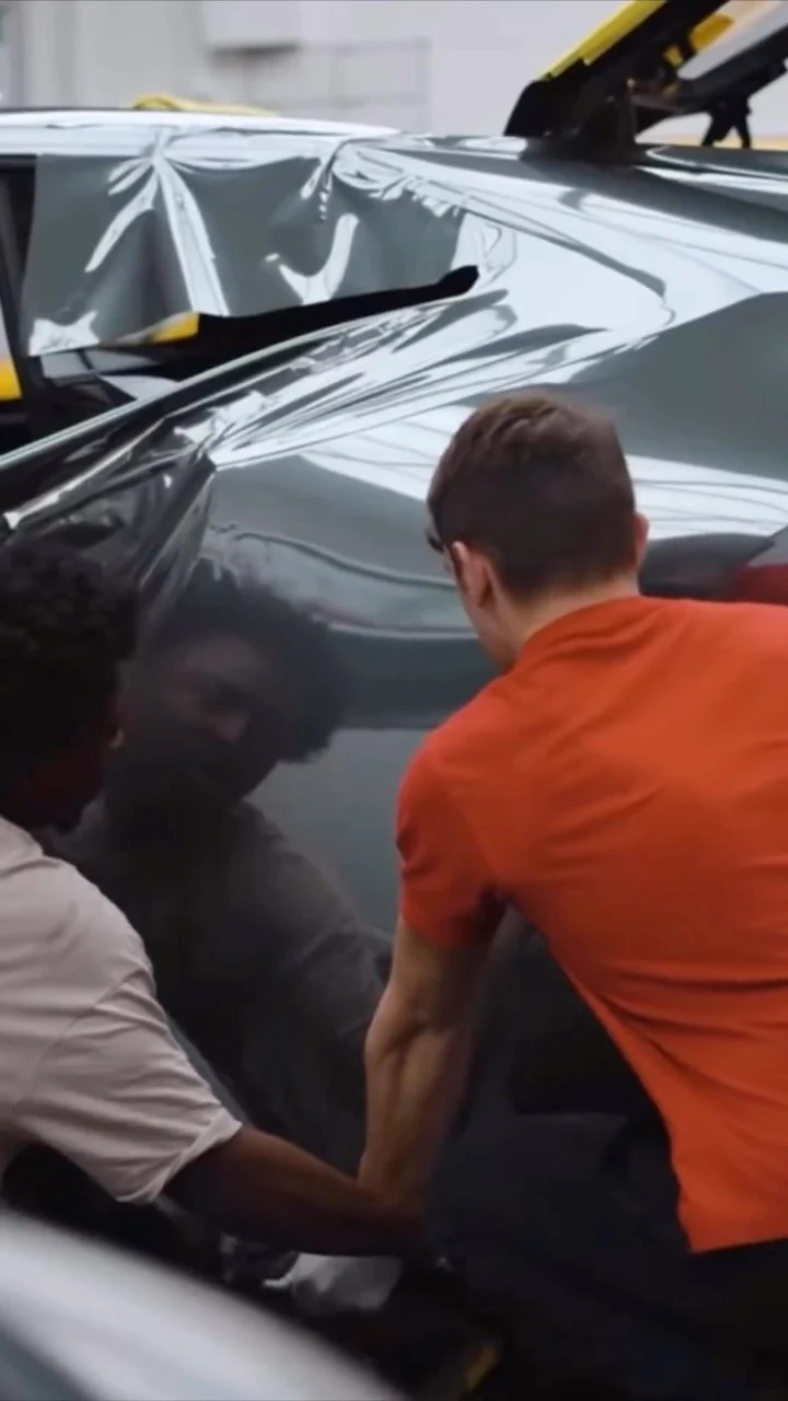 Kean wrapping a grey car inside a large studio unit